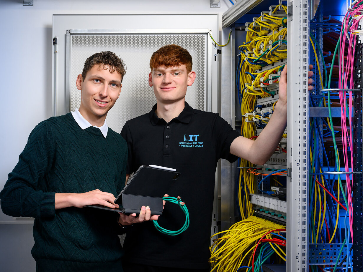 Zwei Mitarbeiter der Leitstelle für IT an einem Schaltschrank
